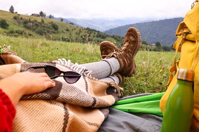 Photo of Woman wearing trekking shoes and lying in tent outdoors, closeup