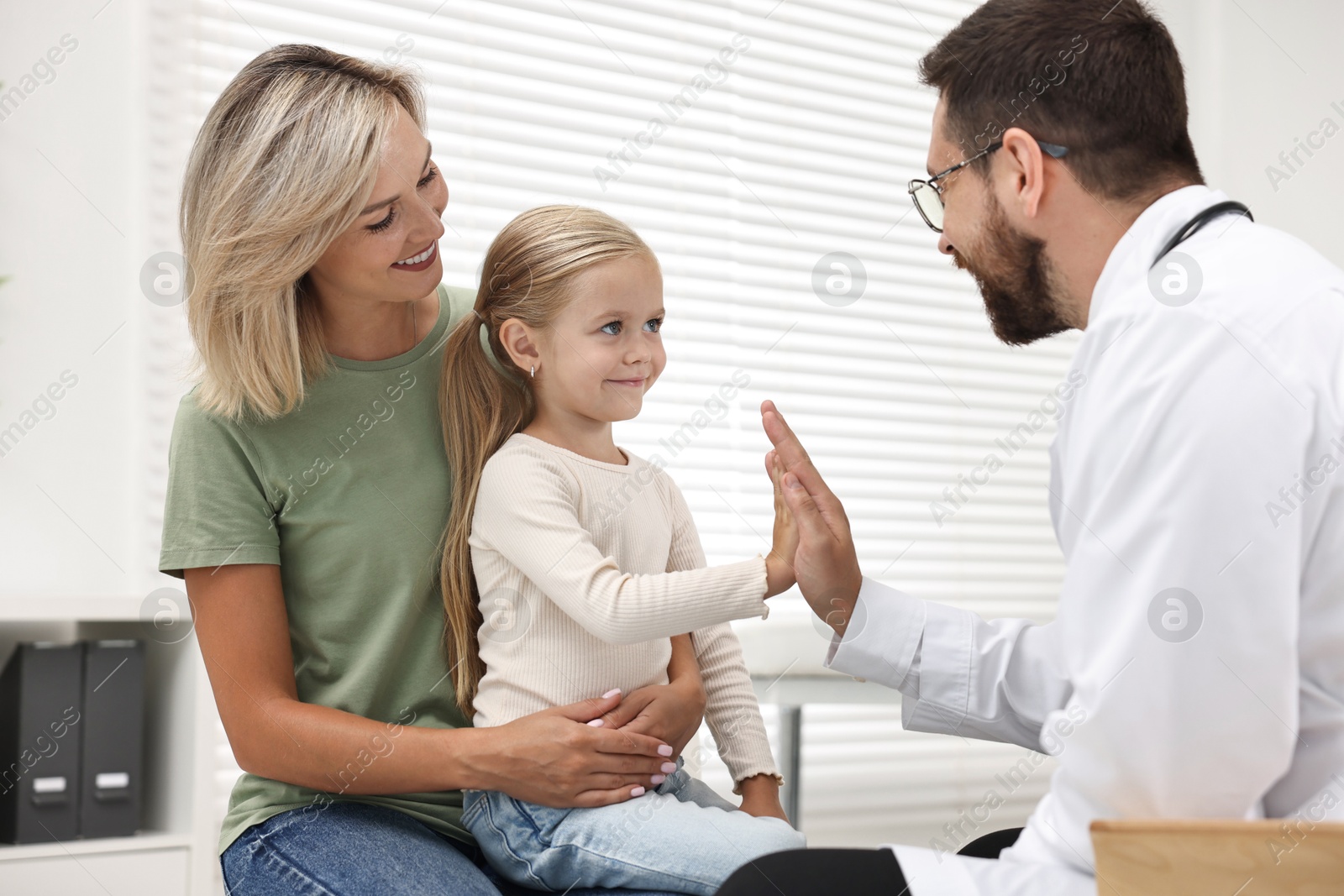 Photo of Mother and her little daughter having appointment with doctor in hospital