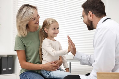 Mother and her little daughter having appointment with doctor in hospital