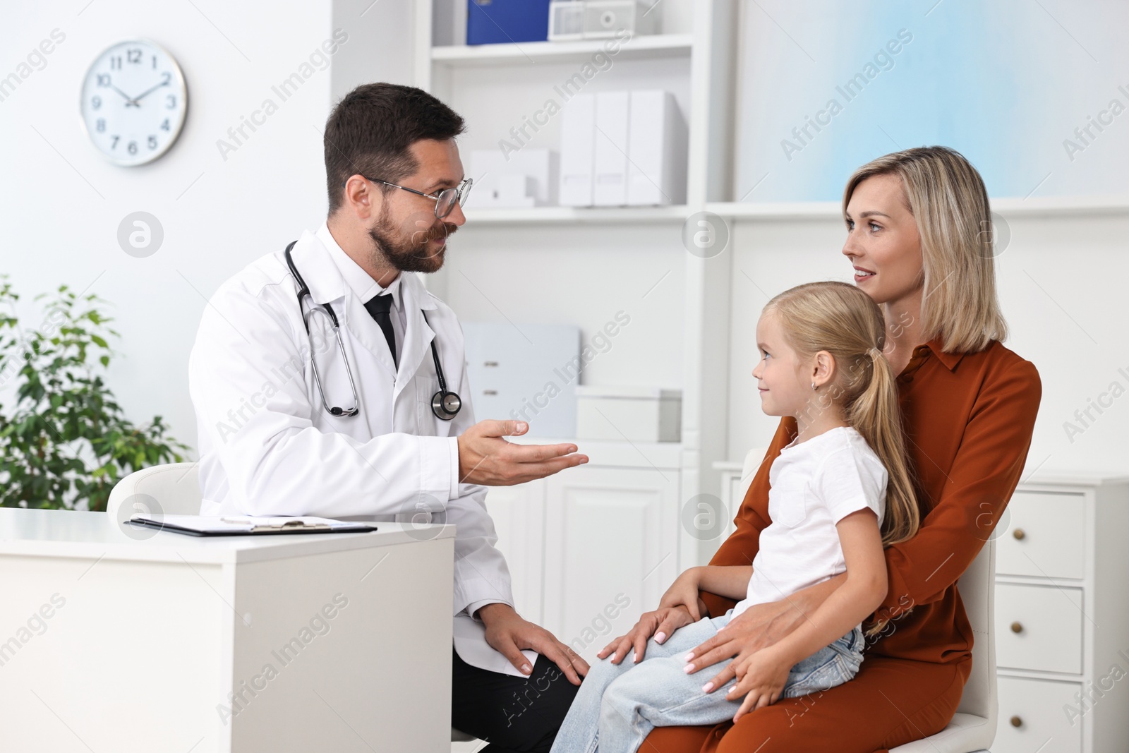 Photo of Doctor consulting little girl and her mother in hospital