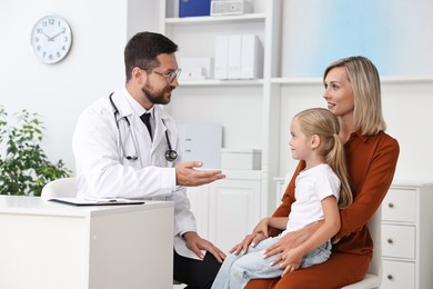 Photo of Doctor consulting little girl and her mother in hospital