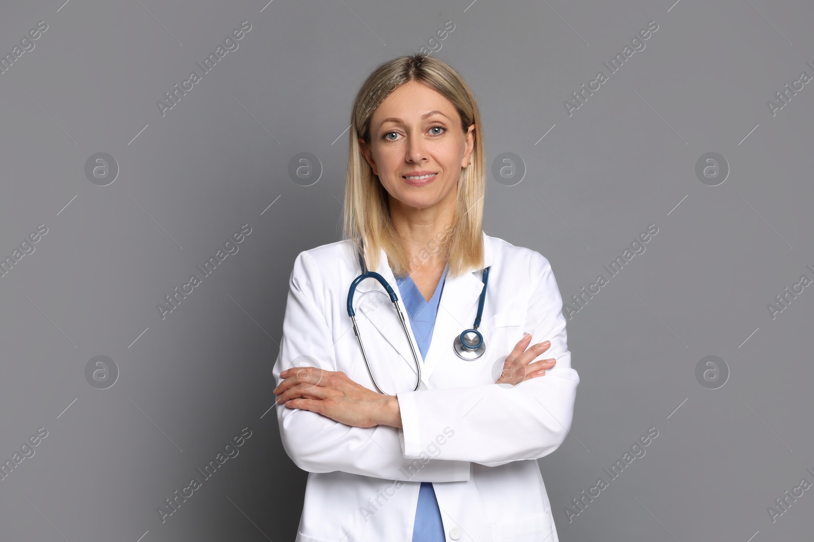 Photo of Portrait of doctor in medical uniform with stethoscope on grey background