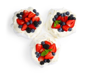 Photo of Pavlova cake (meringue dessert) with whipped cream, fresh berries and mint isolated on white, top view