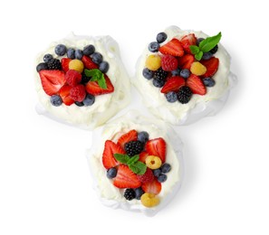 Photo of Pavlova cake (meringue dessert) with whipped cream, fresh berries and mint isolated on white, top view