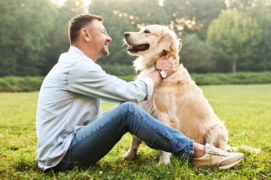 Smiling man with cute Golden Retriever dog on spring day