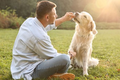 Photo of Man with cute Golden Retriever dog on spring day