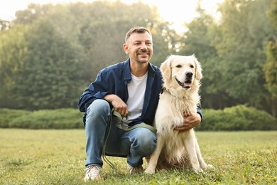 Photo of Smiling man with cute Golden Retriever dog on spring day