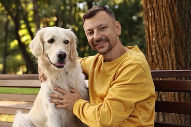 Smiling man with cute Golden Retriever dog on spring day