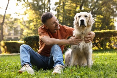 Smiling man with cute Golden Retriever dog on spring day