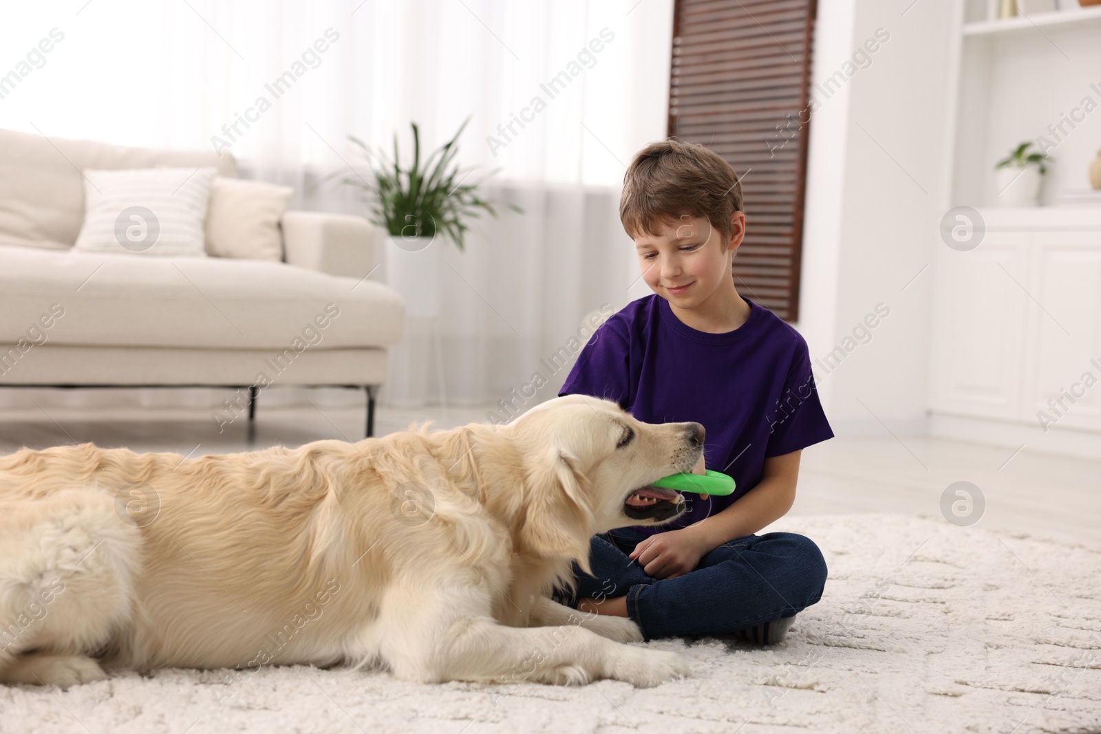 Photo of Boy playing with his cute dog at home