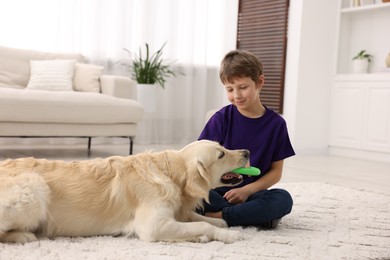 Boy playing with his cute dog at home