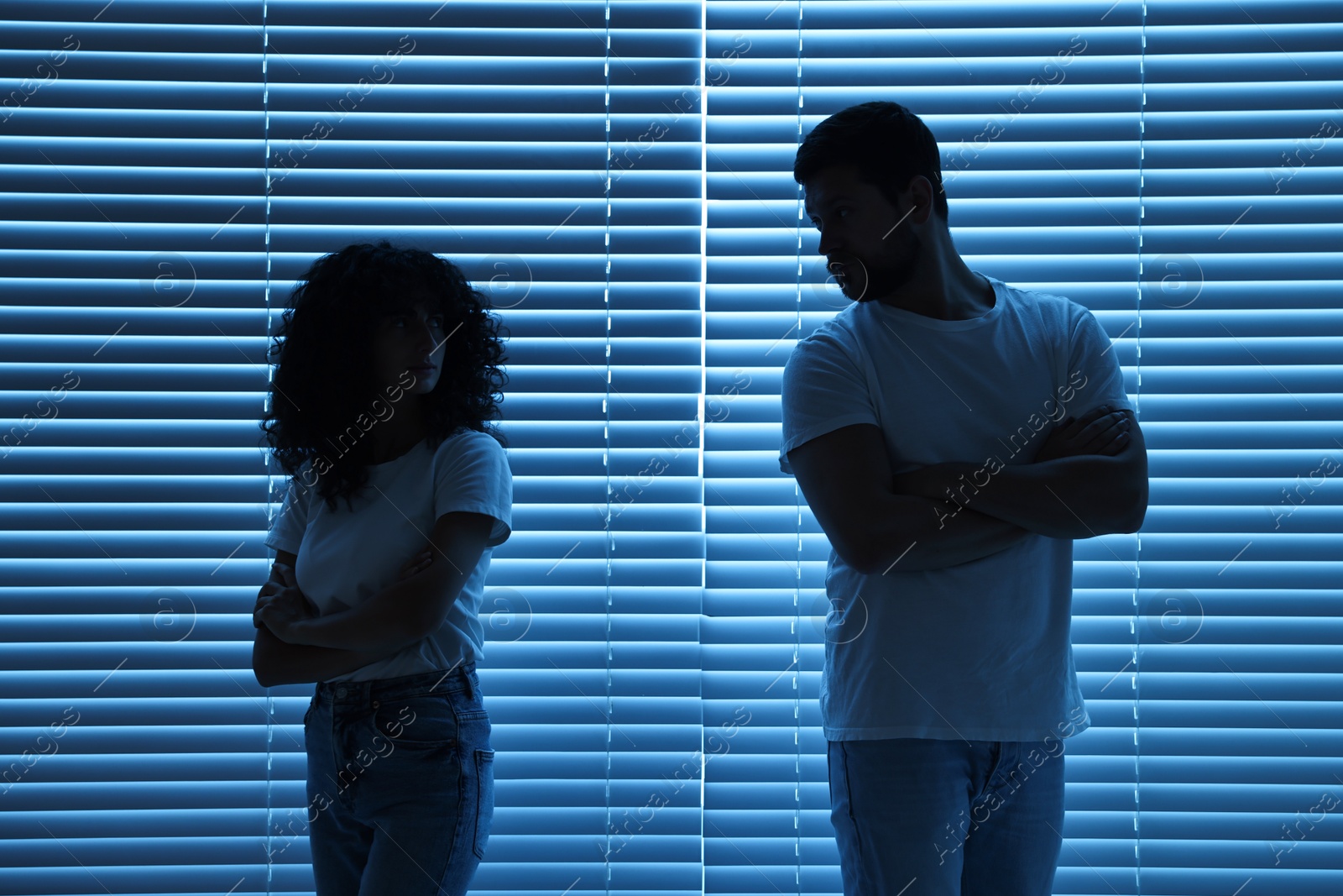 Photo of Couple having quarrel indoors at night. Relationship problems