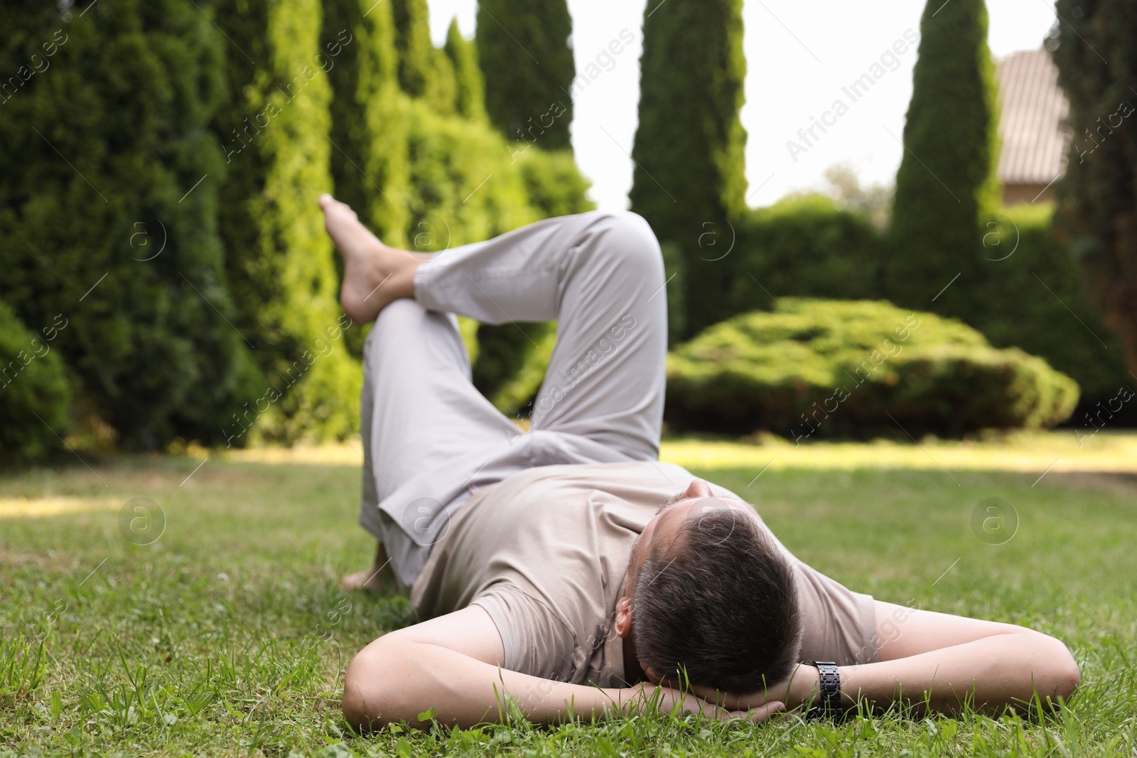 Photo of Man resting on green lawn in park