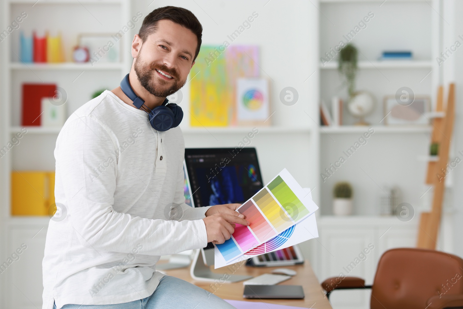 Photo of Smiling designer with color palette in office