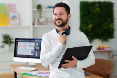 Smiling designer working with tablet in office