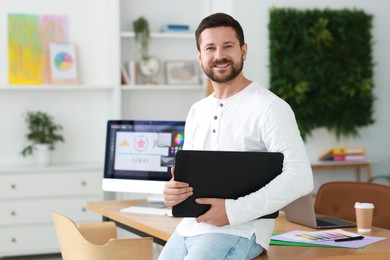 Smiling designer working with tablet in office