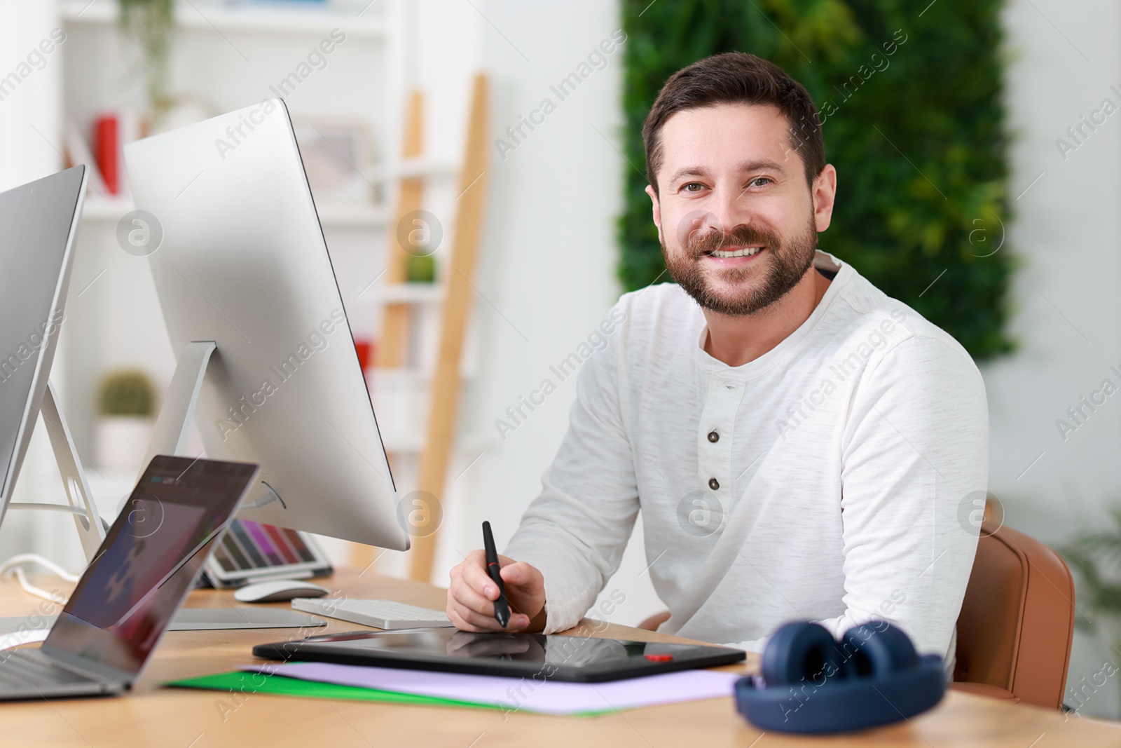 Photo of Designer working with tablet at table in office