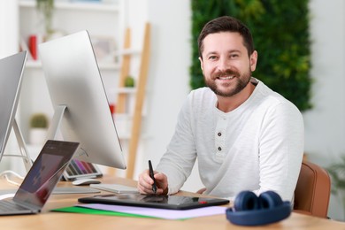 Photo of Designer working with tablet at table in office