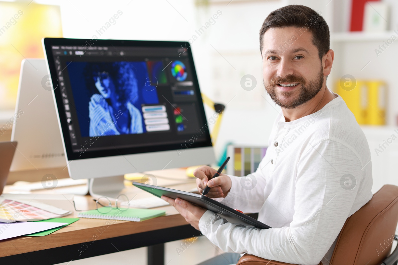 Photo of Smiling designer working with tablet in office