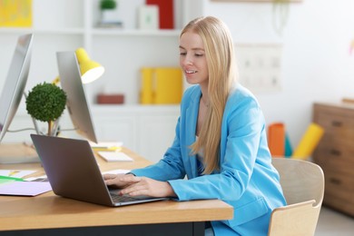 Designer working with laptop at table in office