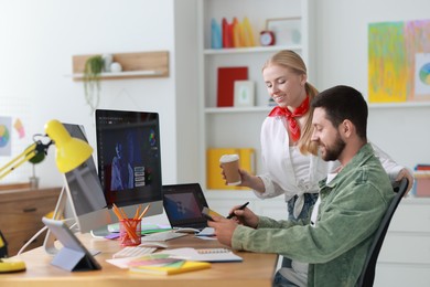 Designers working at table together in office