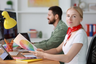 Photo of Designers working together at table in office, selective focus