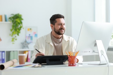 Designer working with tablet at table in office