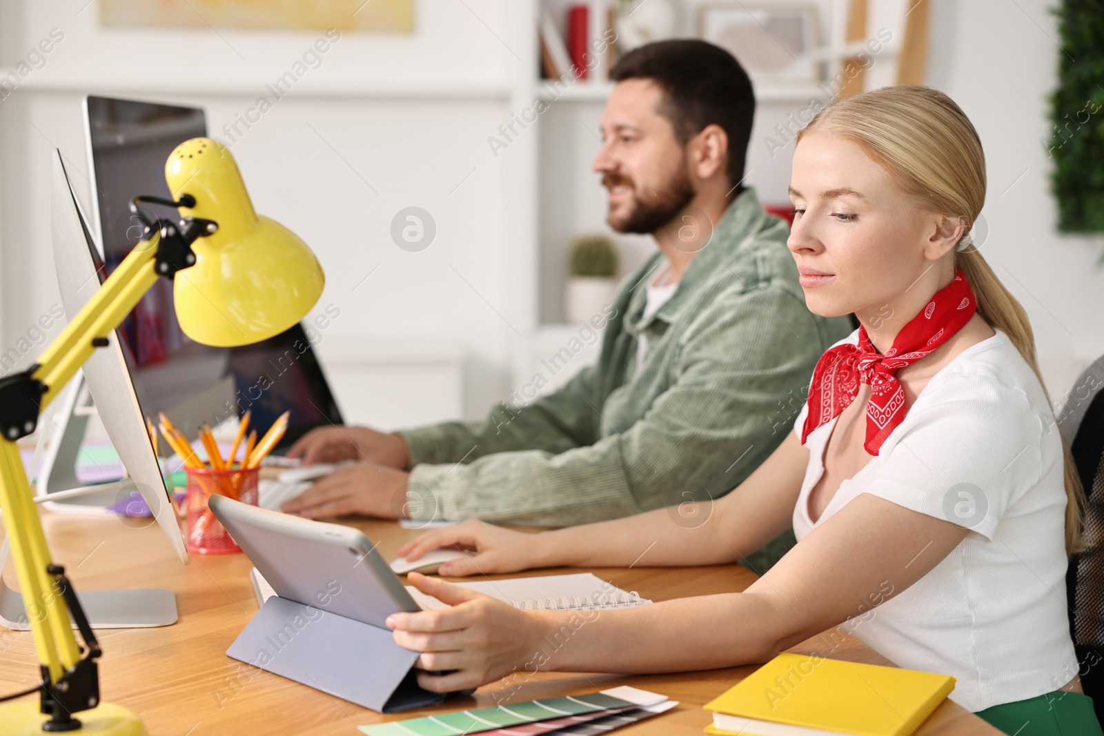 Photo of Designers working together at table in office, selective focus