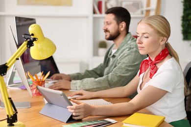 Designers working together at table in office, selective focus