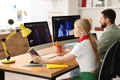 Photo of Designers working together at table in office