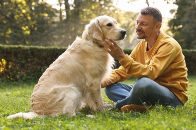 Photo of Smiling man with cute Golden Retriever dog on spring day