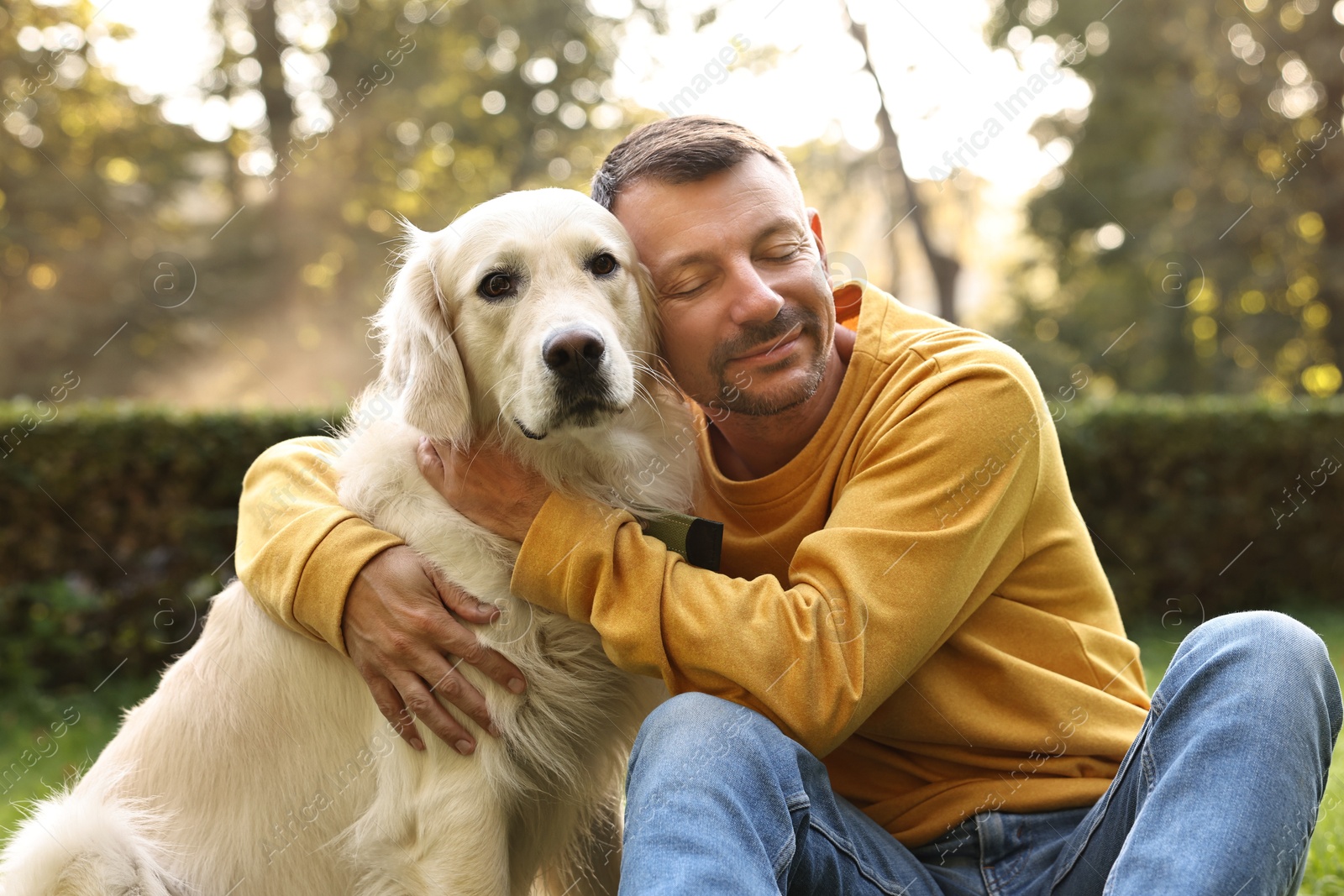 Photo of Man with cute Golden Retriever dog on spring day