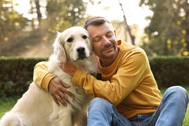 Man with cute Golden Retriever dog on spring day