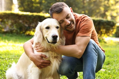 Photo of Man with cute Golden Retriever dog on spring day