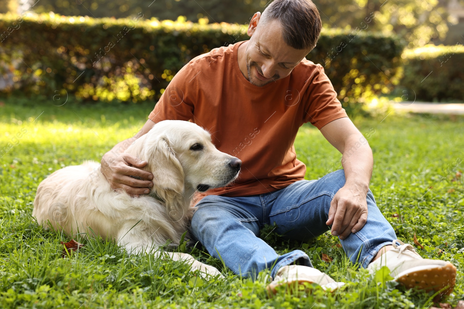 Photo of Man with cute Golden Retriever dog on spring day