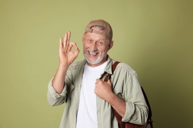 Photo of Portrait of happy senior man showing ok gesture on green background