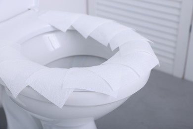 Photo of Toilet seat with paper tissues in bathroom