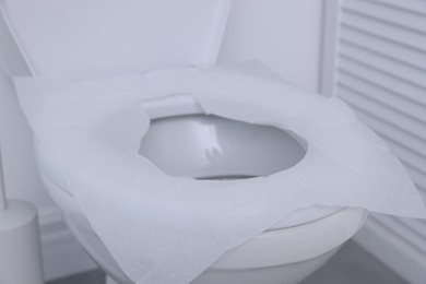 Photo of Toilet seat with paper tissues in bathroom