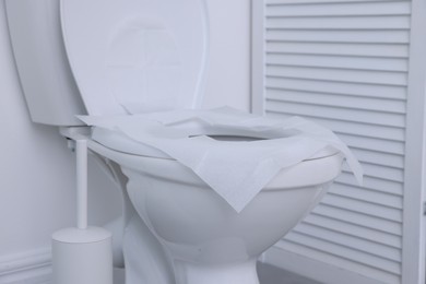 Photo of Toilet seat with paper tissues in bathroom