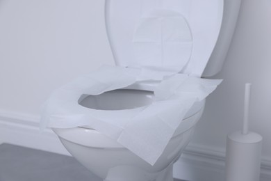 Photo of Toilet seat with paper tissues in bathroom