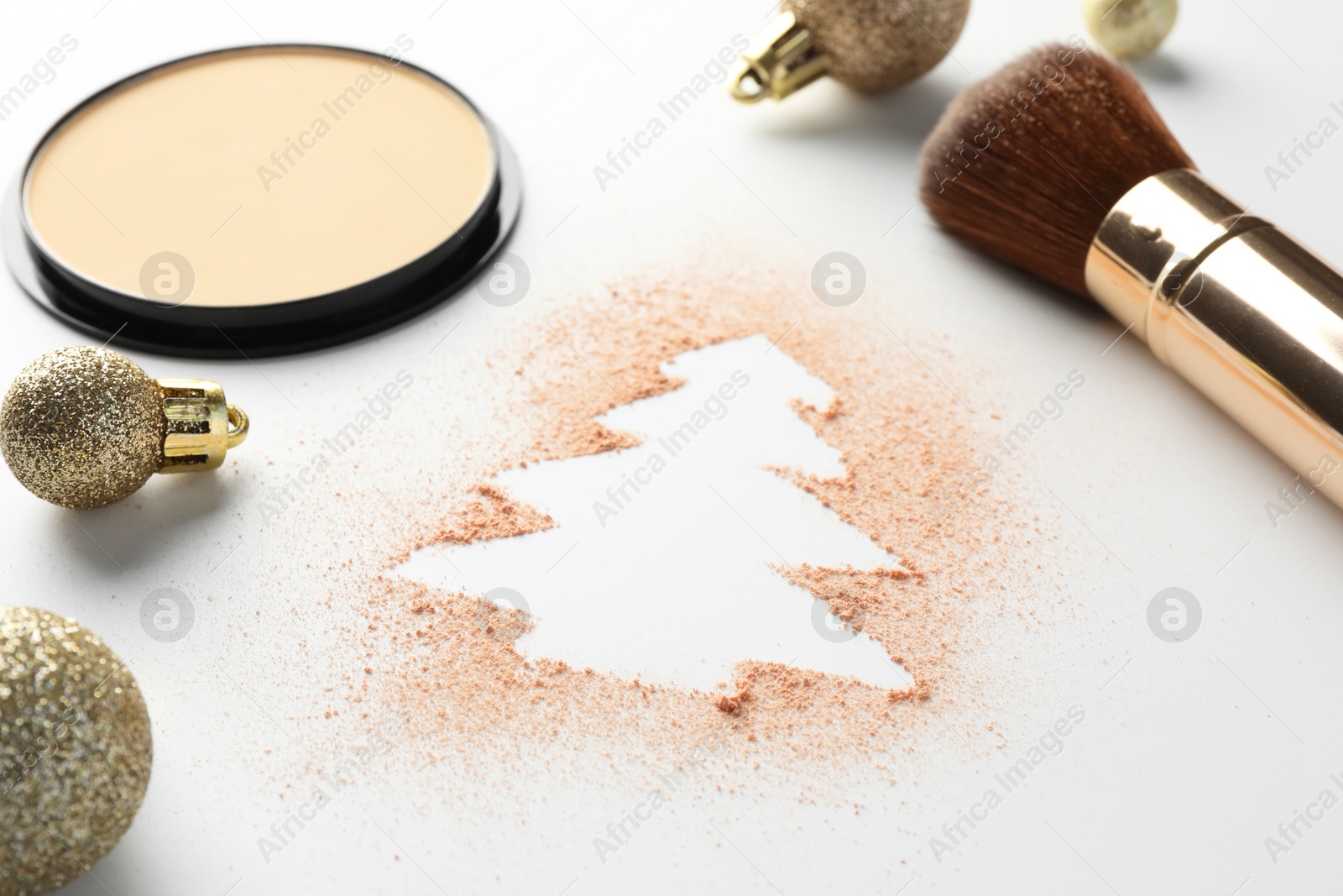 Photo of Christmas tree made of powder, balls and makeup brush on white background, closeup