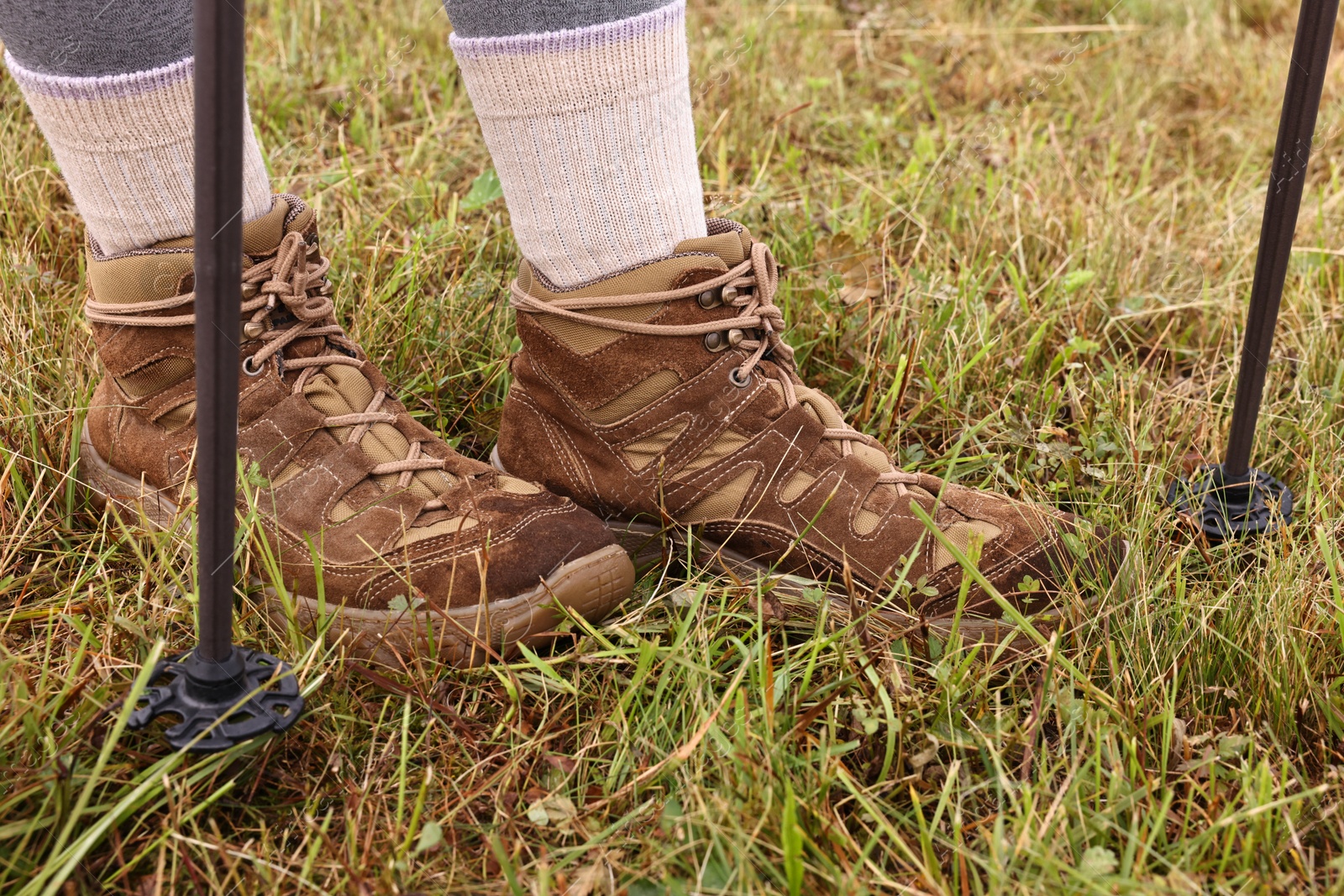 Photo of Young hiker with trekking poles outdoors, closeup