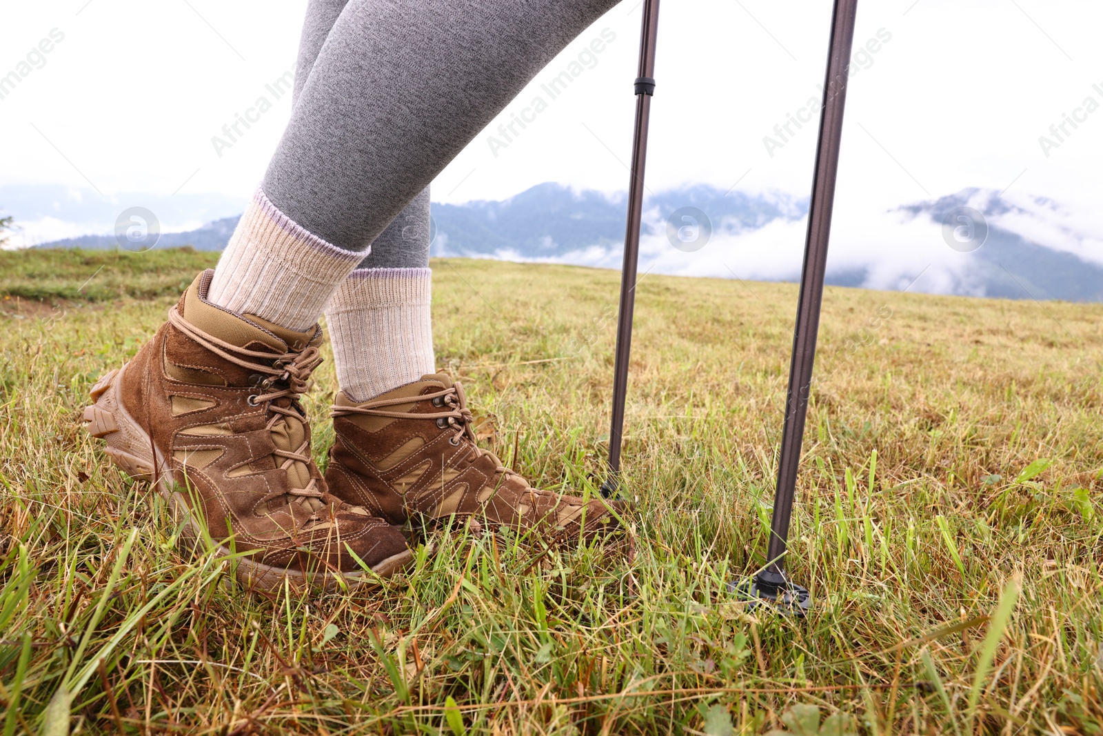 Photo of Young hiker with trekking poles outdoors, closeup