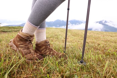 Photo of Young hiker with trekking poles outdoors, closeup