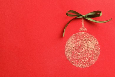 Photo of Christmas ball made with face powder on red background, top view. Space for text