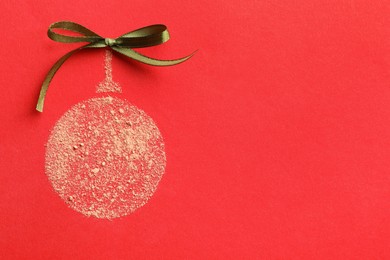 Photo of Christmas ball made with face powder on red background, top view. Space for text