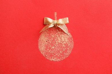 Photo of Christmas ball made with face powder on red background, top view