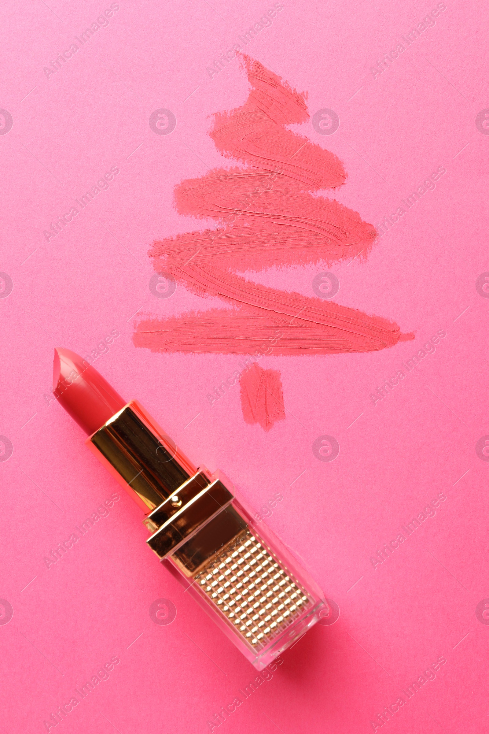 Photo of Christmas tree drawn with lipstick on pink background, top view