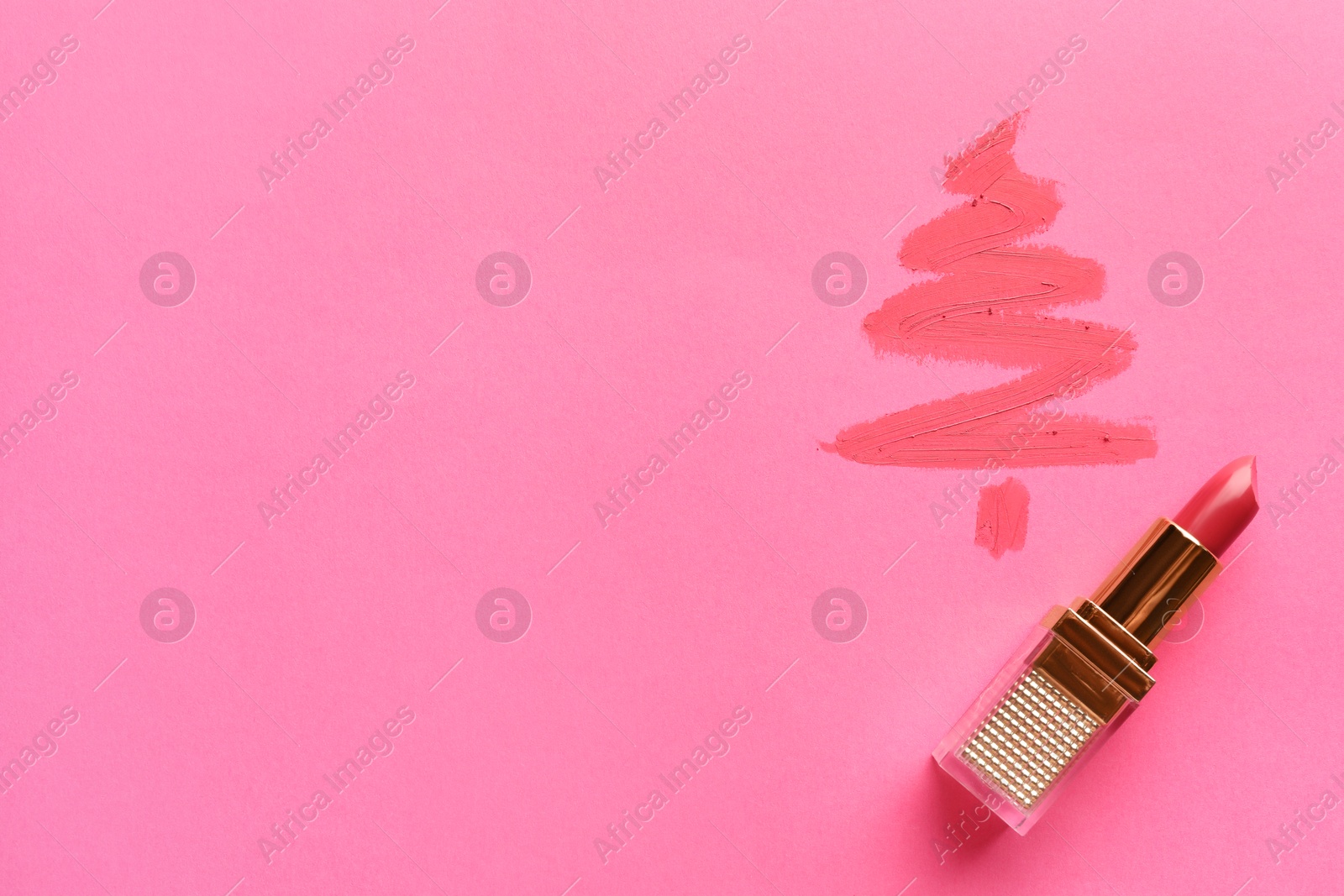 Photo of Christmas tree drawn with lipstick on pink background, top view. Space for text