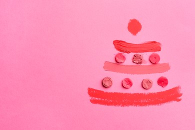 Photo of Christmas tree drawn with lipsticks on pink background, top view. Space for text